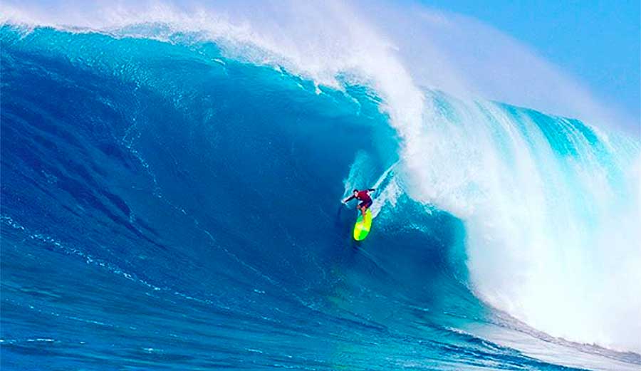 Surfer on massive blue wave