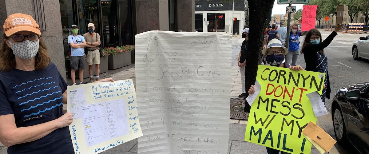 Activists outside John Cornyn's office demanding funding for USPS